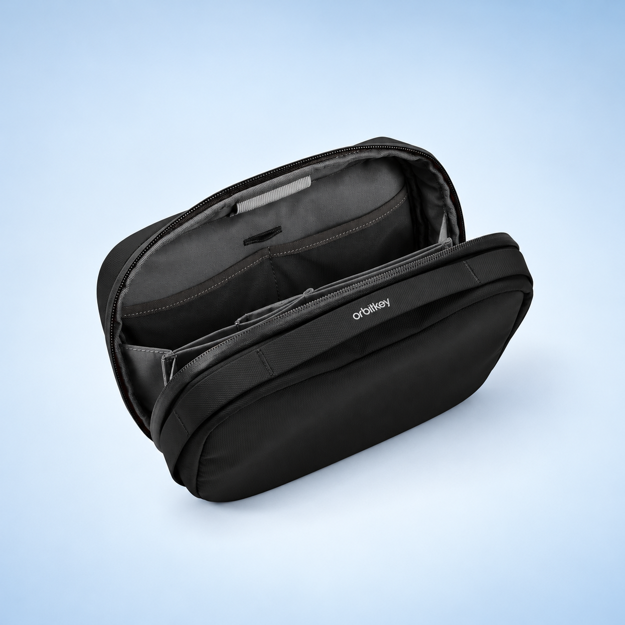 Editorial illustration of Orbitkey 2-in-1 Tech Pouch, black; visible model recognition only, not a technical or complete-pack diagram.