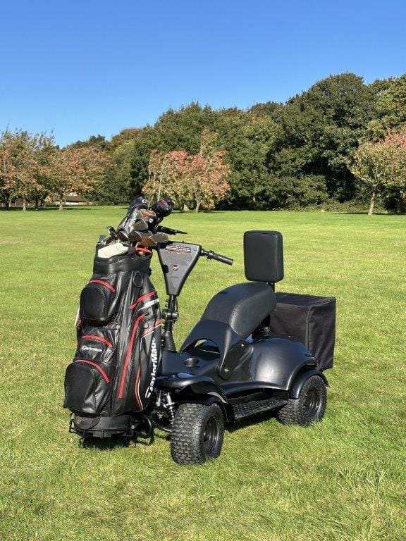 i-m4 Electric Single Seater black four-wheel golf buggy with upright backrest and handlebars on grass